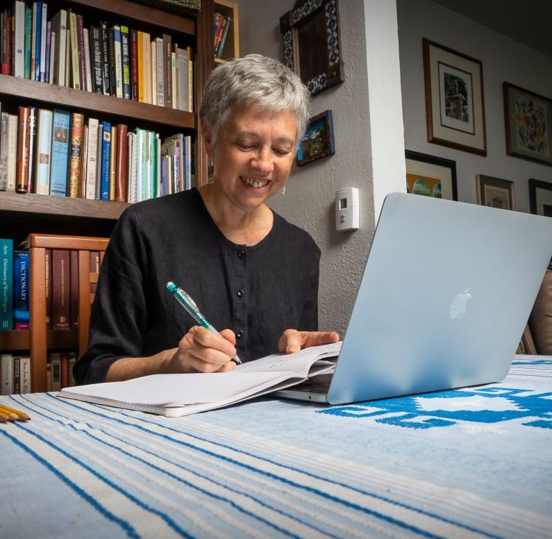 Carla writing at her desk